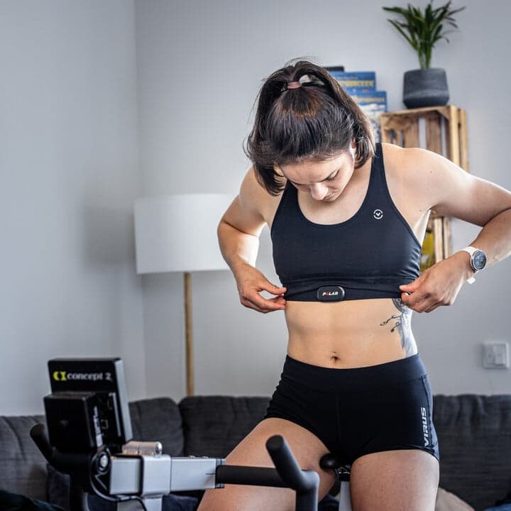 woman on bikeerg using heart rate monitoring