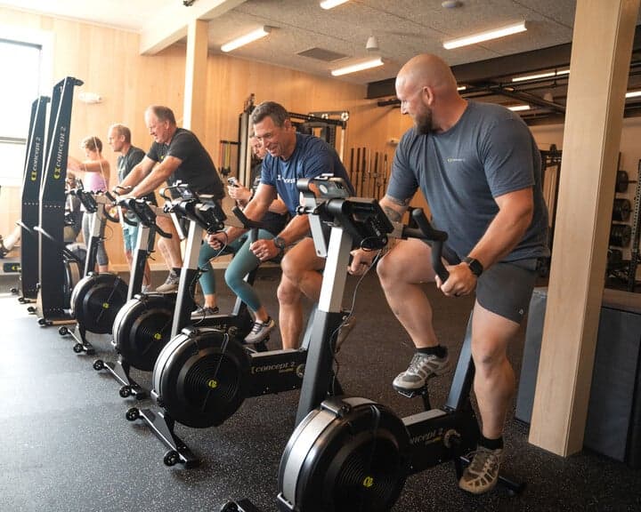 Group of people using Concept2 machines in gym