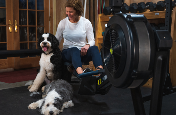 woman on rowerg with dogs